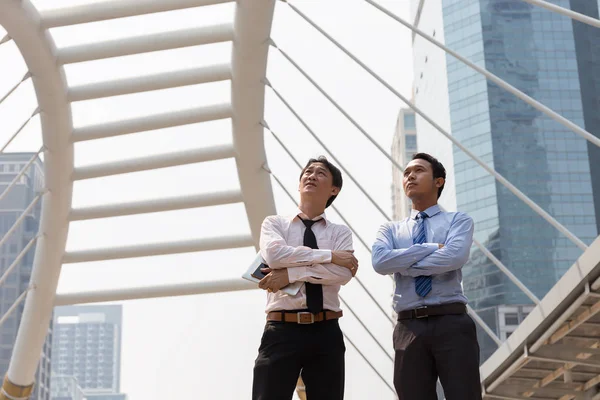 Dos hombres de negocios asiáticos presentes en el distrito de negocios. Imágenes de stock libres de derechos