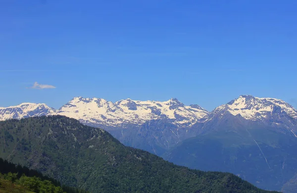 Gama de montanhas com neve e vegetação — Fotografia de Stock