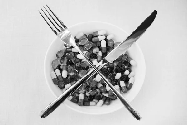 Pillole e capsule in piastra bianca con forchetta e coltello, concetto di bene per la salute alimentare, dieta . — Foto Stock