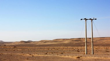 Ürdün Çölü, yüksek gerilim powerlines, sabah erken elektrik direkleri içinde ekilmemiş boş arazi.