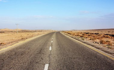 Otoyol Ürdün Çölü, elektrik direkleri asfalt yol Vadisi'nde, gündoğumu sonra vahşi sabahın erken saatlerinde boyunca.