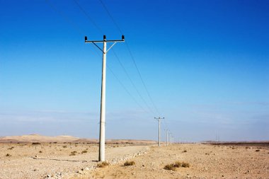 Ürdün Çölü, yüksek gerilim powerlines, sabah erken elektrik direkleri içinde ekilmemiş boş arazi.