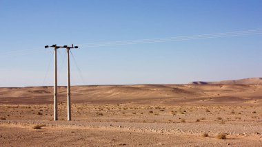 Ürdün Çölü, yüksek gerilim powerlines, sabah erken elektrik direkleri içinde ekilmemiş boş arazi.