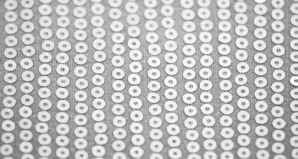 Pale light gray knitted fabric with sequins, background with selective focus. — Stock Photo, Image