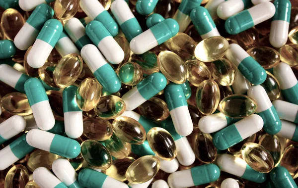 Una dispersione di compresse di diverse forme e colori, sfondo di farmaci medici . — Foto Stock