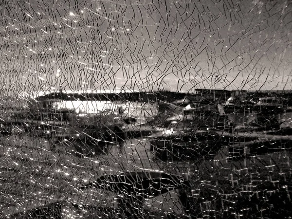 A través de la esgrima de vidrio roto muelle visible, aparcar los barcos. Textura de vidrio roto agrietado . —  Fotos de Stock