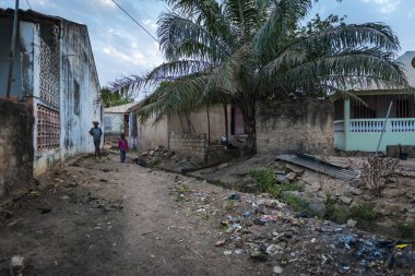 Bissau, Gine Cumhuriyeti - 31 Ocak 2018: iki erkek bir kir sokak şehir Bissau, Gine Bissau Cupelon de Baixo mahallede, açık bir sewre boyunca yürüyüş.