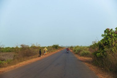 Bissau, Gine Cumhuriyeti - 1 Şubat 2018: bir yol yürüyüş kadınlar yakınındaki şehir Bissau, Gine Bissau, eteklerinde Mansoa Nehri.