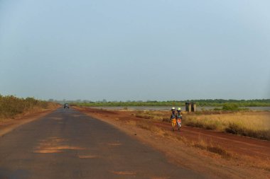 Bissau, Gine Cumhuriyeti - 1 Şubat 2018: bir yol yürüyüş kadınlar yakınındaki şehir Bissau, Gine Bissau, eteklerinde Mansoa Nehri.