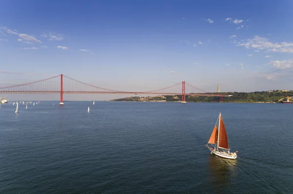 ポルトガル リスボン市に バック グラウンドの 月橋の とテージョ川のボートで美しい帆の航空写真 — ストック写真
