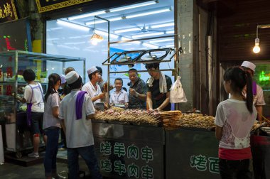 Xian, China - August 6, 2012: People at a food stall in a street of the Muslim Quarter in the city of Xian in China, Asia clipart