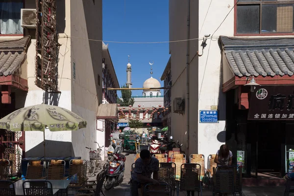 Dunhuang, Çin - 7 Ağustos 2012: Street city Dunhuang, insanlar üzerinde bir stree ve Çin'deki arka planda bir cami ile sahnede
