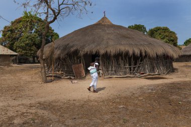 Orango Island, Gine-Bissau 3 Şubat 2018: Orango Adası Eticoga Köyü, arkadaki küçük çocuğunu taşıyan bir anne.