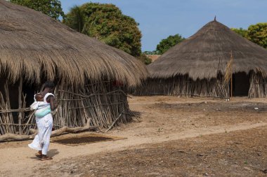 Orango Island, Gine-Bissau 3 Şubat 2018: Orango Adası Eticoga Köyü, arkadaki küçük çocuğunu taşıyan bir anne.