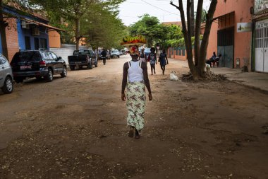Bissau, Gine Cumhuriyeti - 5 Şubat 2018: bir muz ile başında, Gine Bissau, Batı Afrika tepsi bir kadınla Bissau şehir sokak sahne
