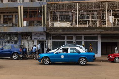 Bissau, Gine Cumhuriyeti - 5 Şubat 2018: Bissau şehir bir taksi ve insanların önünde bir çökmekte bina, Gine Bissau, Batı Afrika ile sahnede sokak