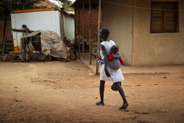 Bissau, Gine Cumhuriyeti - 6 Şubat 2018: şehir Bissau, Gine Bissau Missira mahallede, bebeğini ona geri taşıyan anne