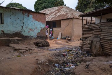 Bissau, Gine Cumhuriyeti - 6 Şubat 2018: bir gecekondu ile bir açık hava kanalizasyona evlerinde önünde şehir Bissau, Gine Bissau oynayan çocuklar