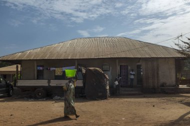 Bissau, Gine Cumhuriyeti - 7 Şubat 2018: sokak sahne su başında, Gine Bissau, Batı Afrika kova taşıyan bir kadınla Bissau şehir merkezi