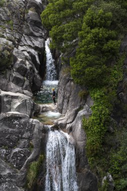 Cascata do Arado, Vilar da Veiga, Portekiz - 10 Haziran 2019: Portekiz'deki Peneda Geres Milli Parkı'ndaki Arado Şelalesi'nde (cascata do arado) kanyon da bulunan bir adam