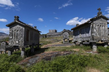 Portekiz'in tarihi Lindoso köyünde tahıl ambarlarının (espigueiros) ve ortaçağ kalesinin görünümü.