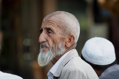 Kaşgar, Sincan, Çin - 14 Ağustos 2012: Kaşgar şehrinde bir sokak pazarında bir Uygur adam Portresi, Sincan, Çin