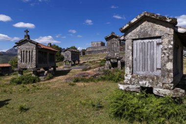 Portekiz'in tarihi Lindoso köyünde tahıl ambarlarının (espigueiros) ve ortaçağ kalesinin görünümü.