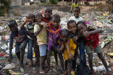 Bissau, Republic of Guinea-Bissau - February 8, 2018: Group of children at a landfill in the city of Bissau, in Guinea-Bissau, West Africa clipart