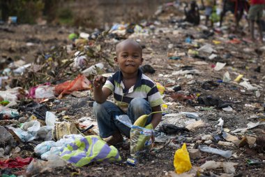 Bissau, Gine-Bissau Cumhuriyeti - 8 Şubat 2018: Gine-Bissau, Batı Afrika'daki Bissau kentindeki bir çöplükte çöp toplayan afrikalı genç çocuk