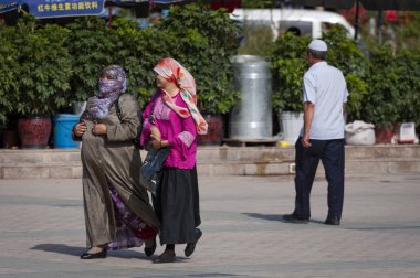 Kashgar, Xinjiang, Çin-14 Ağustos 2012: Kashgar, Xinjiang, Çin kentinde bir sokakta Iki Uygur kadın