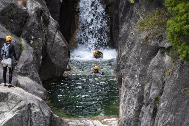 Cascata do Arado, Vilar da Veiga, Portekiz - 10 Haziran 2019: Portekiz'deki Peneda Geres Milli Parkı'nda Arado Şelalesi'ne (cascata do arado) rappelling bir adam.