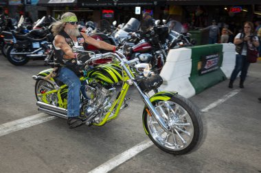 Sturgis, Güney Dakota - 9 Ağustos 2014: Sturgis şehrinin ana caddesinde düzenlenen geleneksel Sturgis Motosiklet rallisinde motosikletine binen bir bisikletli. 
