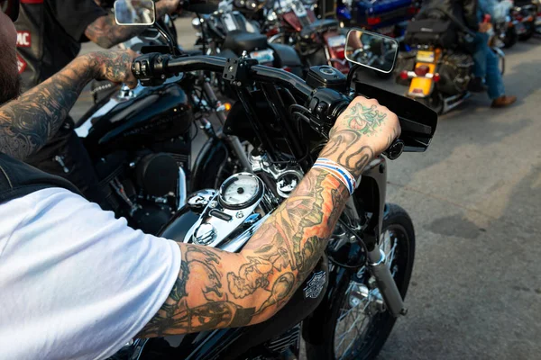 stock image Sturgis, South Dakota - August 9, 2014: Detail of the tattooed harm of a byker riding his chopper motorcycle during the annual Sturgis Motorcycle rally in the main street of the city of Sturgis. 