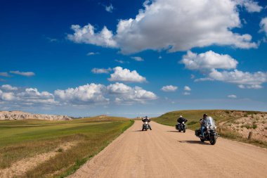 Badlands Ulusal Parkı, Güney Dakota - 9 Ağustos 2014: Badlands Ulusal Parkı 'ndaki toprak yolda motosiklet süren motorcular.