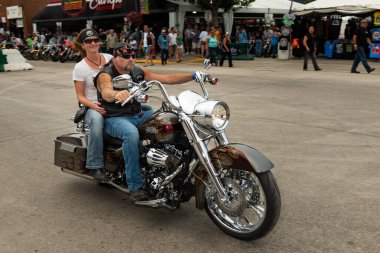 Sturgis, Güney Dakota - 8 Ağustos 2014: Sturgis şehrinin ana caddesinde düzenlenen geleneksel Sturgis Motosiklet rallisinde motosikletine binen bir bisikletli.