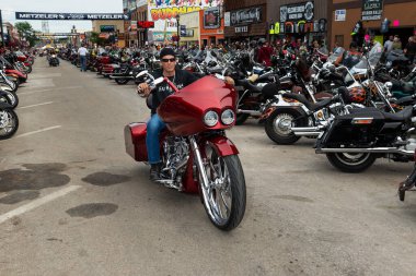 Sturgis, Güney Dakota - 8 Ağustos 2014: Sturgis şehrinin ana caddesinde düzenlenen geleneksel Sturgis Motosiklet rallisinde motosikletine binen bir bisikletli. 