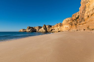 Portekiz 'in Algarve bölgesindeki manzaralı Marinha Sahili (Praia da Marinha) manzarası; Portekiz' e seyahat ve yaz tatilleri kavramı.