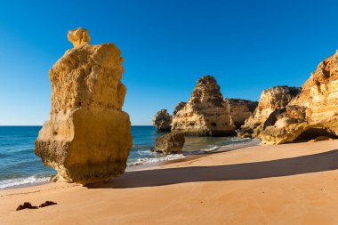 Portekiz 'in Algarve bölgesindeki manzaralı Marinha Sahili (Praia da Marinha) manzarası; Portekiz' e seyahat ve yaz tatilleri kavramı.