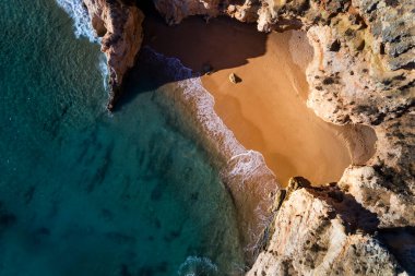 Portimao, Algarve, Portekiz 'deki Prainha Sahili' nin yakınlarındaki uçurumlarla çevrili küçük, güzel bir sahil manzarası.