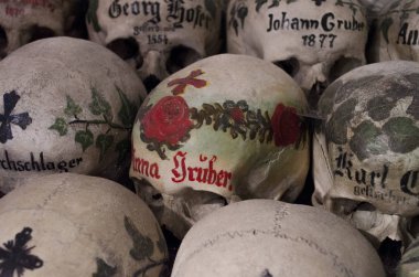 Skulls painted with names, colorful flowers and crosses in the Charnel House or Beinhaus, Hallstatt, Austria clipart