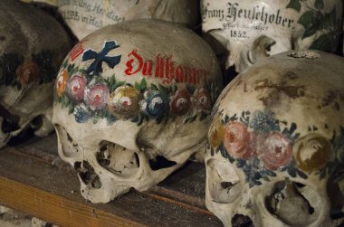 Kafatasları adlarıyla, renkli çiçekler boyanmış ve mezarlık evi veya Beinhaus, Hallstatt, Avusturya geçerek