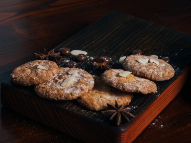 Kurabiye, şeker, krema ile kaplı Baharatlar için kahve, kahve, çay, badem, fındık, karanlık bir ahşap tahta üzerinde şeker,