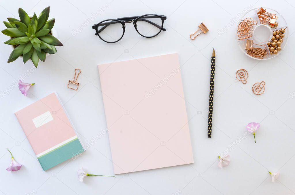 Flat lay, top view office table desk workspace with office accessories including blank paper for lettering, notepad, glasses and plant on white background. mockup