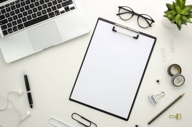 Beyaz arka plan üzerinde gümüş defter ve ofis aksesuarları ile ev ofis resepsiyon çalışma alanı.
