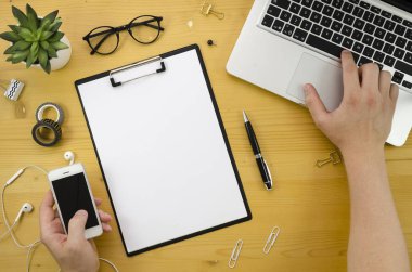 Yönetim Kurulu mockup adam ellerini defter, smartphone, ofis aksesuarları ile ahşap Resepsiyon arka plan üzerinde küçük. Internet üzerinden iş yapan adam. Düz yatıyordu