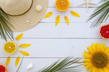Alan yazı surronded tarafından güzel bir yaz şapka ile çerçeve objects, palmiye yaprakları, Taze narenciye, ayçiçeği ve deniz yıldızı Beyaz ahşap zemin üzerinde. Yat, görünümü top, alan sahte kopyalayın