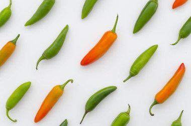 Beyaz zemin üzerine kırmızı, sarı ve yeşil biber düzenlenmiştir. Çapraz yönde bileşiminde sebze. Düz yatıyordu üstten görünüm