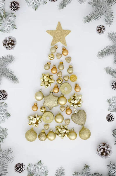 Karácsonyfa készült új évet dekorációt, arany golyó, szív, gyertya, bell és a téli dolog, a fehér hátterű keret fenyő ágak és kúpok. Üdvözlőlap-ünnep. Lapos laikus minimál design — Stock Fotó