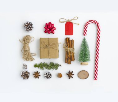 Noel tebrik kartı. Kompozisyon şeklinde kare beyaz zemin üzerine yapılmış koniler, Anason yıldız, köknar dalı, yay, ip şeker, tarçın, yılbaşı ağacı, hediye kutusu, fındık, etiket. Düz yatıyordu üstten görünüm