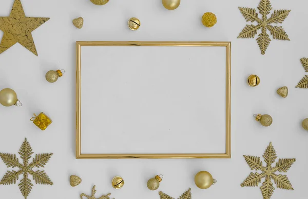 gold Christmas frame on white background with golden christmas decorations snowflakes, balls on white background. Flat lay, top view, copy space for lettering greetings art work